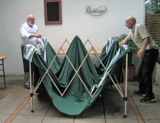 Uwe und Mitarbeiter bauen den Grillstand auf.